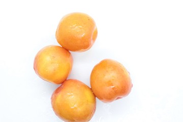 Beautiful delicious orange plums are located on a white background