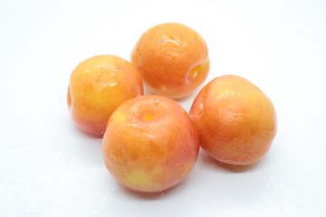 Beautiful delicious orange plums are located on a white background