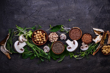 Superfoods, microgreens, mushrooms, seeds, nuts and grains on dark background, healthy eating. Top view