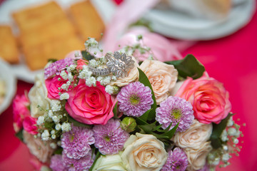 close up wedding ring on top of a colorfull bouquet. . macro .Close up of wedding rings on the bouquet . Macro . Bride and groom with Engagement gold rings put on the clorfull wedding bouquet .