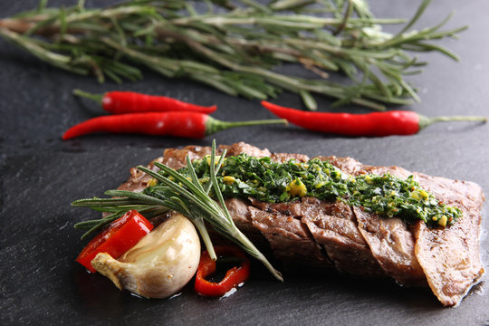 Concept of Mexican cuisine. Meat steak with sauce pesto and chili pepper on a dark background. Background image, copy space