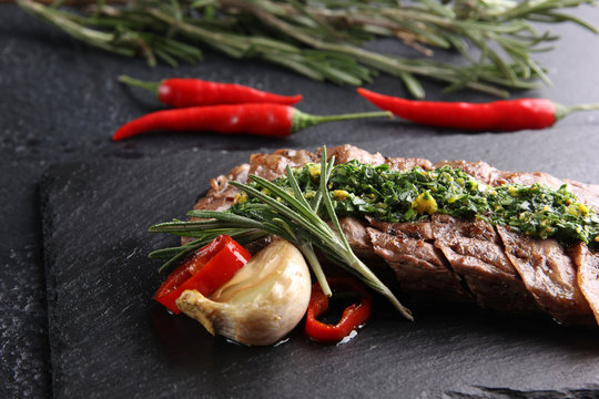 Concept of Mexican cuisine. Meat steak with sauce pesto and chili pepper on a dark background. Background image, copy space