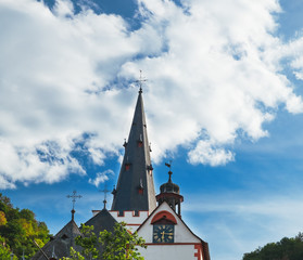 Fototapeta na wymiar Silhouette of German church bell tower with antique clock, Stiftskirche St Goar Evangelical Church under blue cloudy sky, located in St Goar Town, Germany