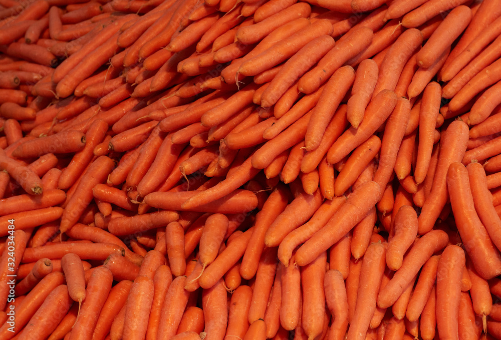 Wall mural fresh orange carrots at the street market,.laid out by the mountain on the counter