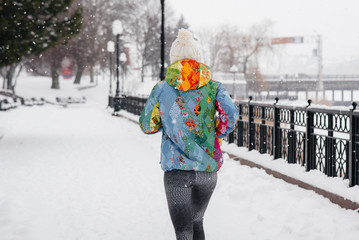 A beautiful young girl is Jogging on a frosty and snowy day. Sports, healthy lifestyle