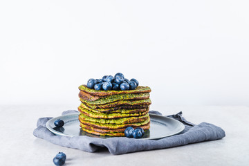 Healthy easy blender green pancakes made from spinach, coconut milk, banana and oats with blueberries. Vegetarian and gluten free breakfast