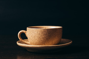 Cup with black coffee on a black background.