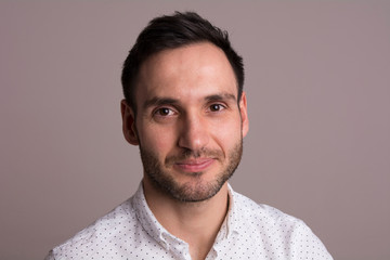 Obraz premium Portrait of a handsome young man. Elegant pose with white dots shirt.