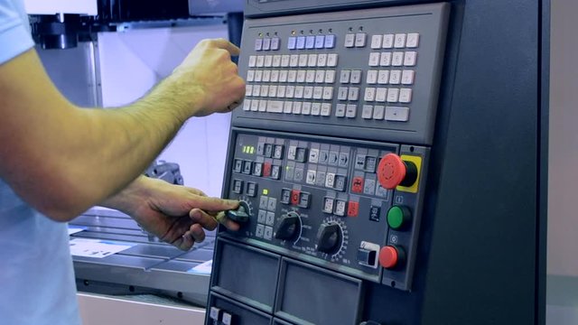 Man working on the control panel works with an industrial machine at the factory