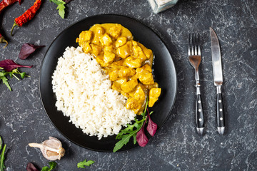Rice with chicken in curry sauce on a plate with horizontal top view. - obrazy, fototapety, plakaty