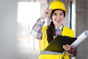 Portrait of a female engineer at construction site and with a clipboard in hands