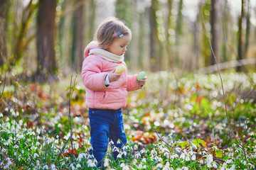 Cute little girl playing egg hunt on Easter