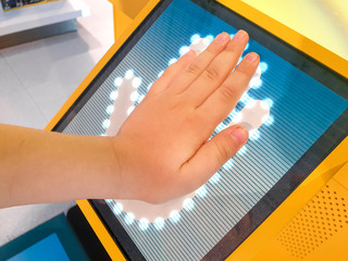 Closeup image of child holding hand on digital fingerprint scanner. Concept of digital security