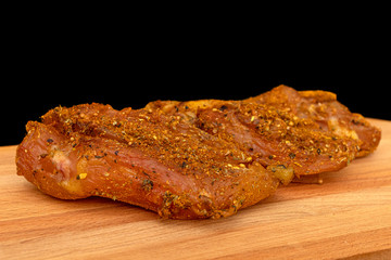 Turkey pastirma with spices against a black background