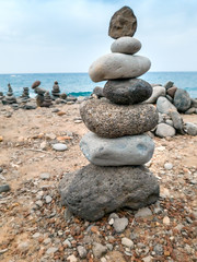 Closeup image of stones balancing on each other on the ocean beach. Concept of harmony and balance