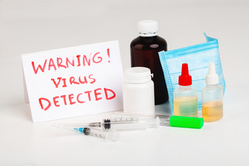Various medications, pills, syringes, medical mask, text VIRUS DETECTED on white background.