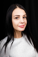 Portrait of serious beautiful female with black hair, has minimal makeup, looks calmly at camera,...