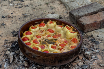 Delicious stuffed peppers with minced meat and covered with slice of tomato and cooked outside on firewood. Food concept. Serbian food.