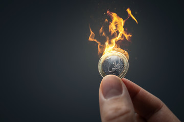 Hand with burning Euro coin