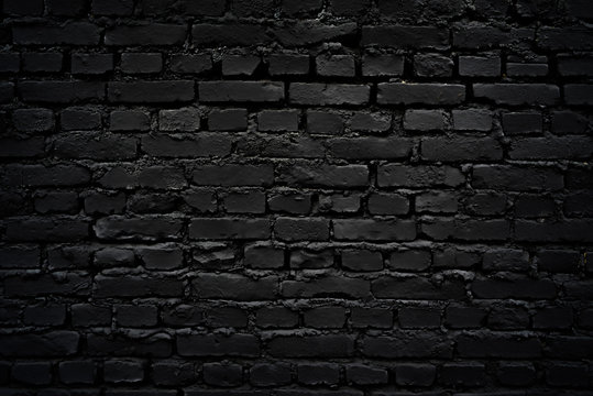 Texture of a perfect black brick wall as background or wallpaper