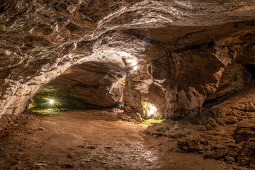 View inside the ancient cave with stone walls with additional lighting. Texture of a stone wall in a cave.