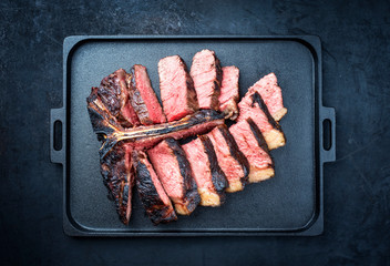 Barbecue dry aged wagyu porterhouse beef steak sliced with large fillet piece as top view on a...