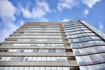 Modern office building wall made of steel and glass with blue sky