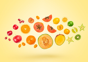 Flying Fruits healthy food summer color background. Papaya, orange, kiwi, melon. Colorful levitation, falling fly fruit creative concept. Vitamin vegan meal. Fresh tropical fruit on yellow