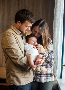 Lovely Family Of Young Parents And Baby At Home