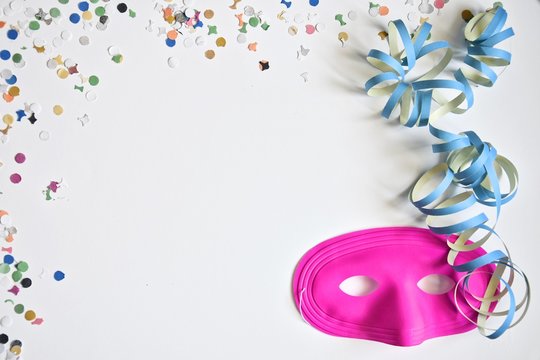 carnival masks with confetti and streamers on a white background