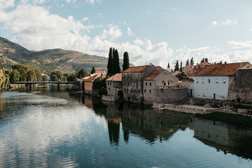 Fototapeta na wymiar Picturesque landscape view of beautiful old city of Trebinje and Trebisnjica river, Bosnia and Herzegovina. Reflections of city on river. September, 2018.