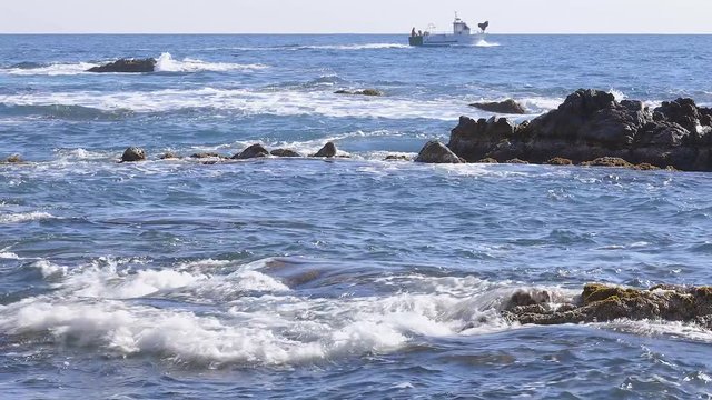 Beautiful seascape of Spanich Costa Brava in Catalonia, in the distance a small fishing boat