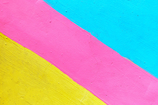 Abstract texture of plaster light blue and yellow with pink-colored line. © gesrey