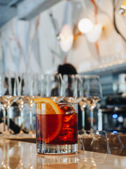 Red alcohol cocktail in glass with orange and ice