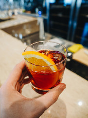 Red alcohol cocktail in glass with orange and ice