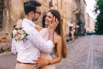 the guy in eyeglasses hugs the girl and touches her hair. girl i