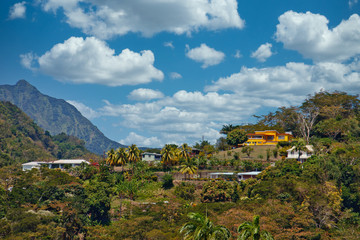 Fototapeta na wymiar Colorful homes clinging to hills on a tropical island