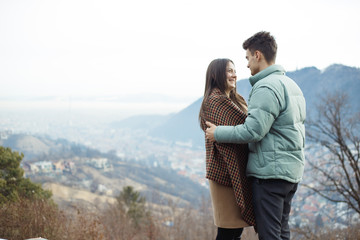 Happy young couple with a panoramic view in background. Love concept. Relationship happiness.