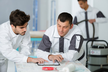 Obraz premium male decorators looking at clipboard