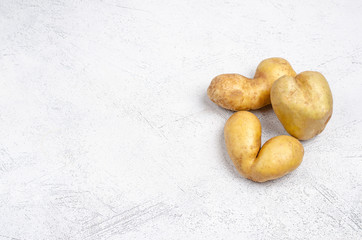 Despicable potatoes of different shapes on a gray background, copy space