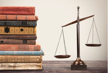 Law scales and books on wooden table. Symbol of justice