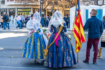 Fototapeta premium Women Falleras of Valencia from behind. Colorful medieval Valencian , Spanish dresses. 