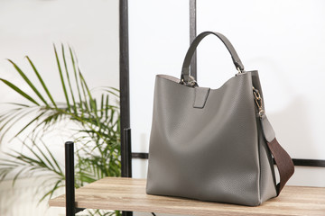 Grey woman's bag on wooden shelf in store