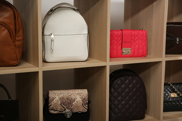 Fototapeta na wymiar Collection of stylish woman's bags on wooden shelving unit