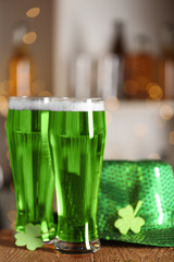 Traditional Irish green beer, shamrock and hat on wooden counter . St.Patrick's Day celebration