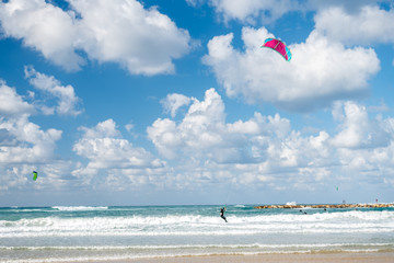 Kiter with blue red kite in the sea in Tel Aviv