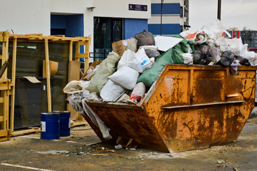 Large iron industrial trash can. A mess with garbage with dirt, poor safety, unsanitary conditions...