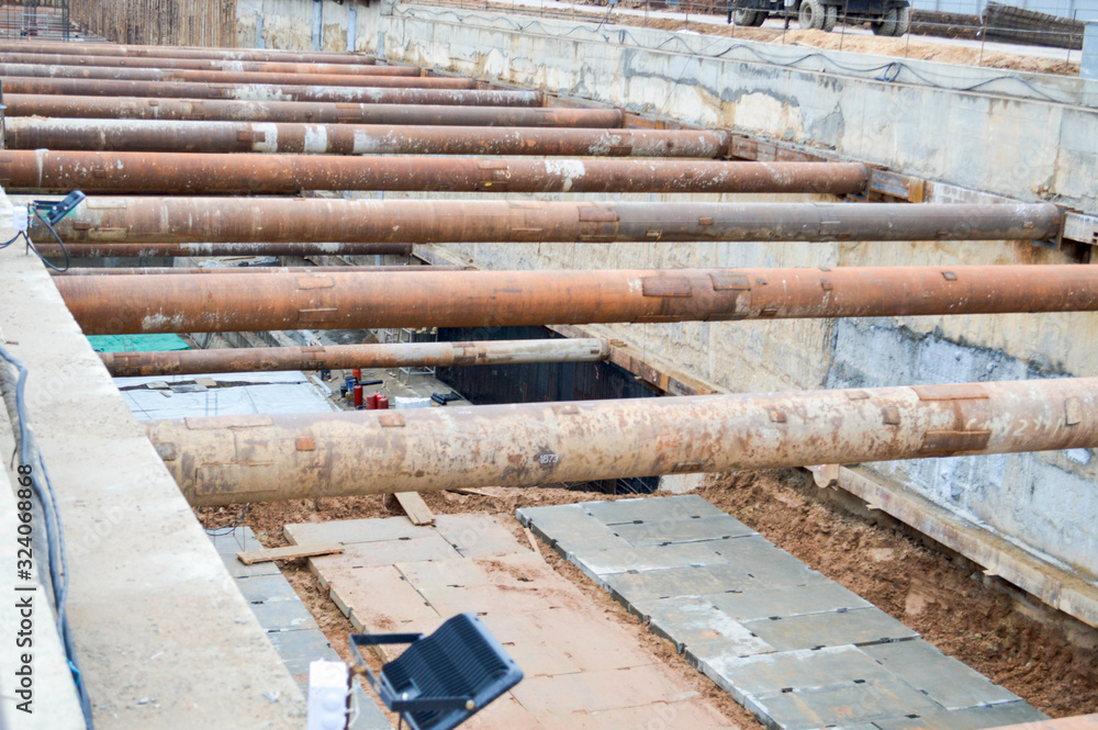 Poster a large huge ditch pit tunnel with reinforcing structures from thick iron pipes of beams and structu