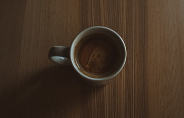 Café en taza blanca sobre mesa de madera