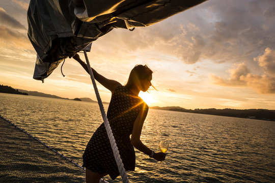 Woman Holding Wine Glass Standing On Board A Boat, Sunset Dinner Cruise On Indian Ocean.,Langkawi